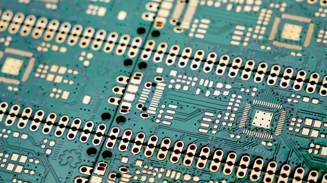 Close-up view of a green circuit board with numerous electronic components, including resistors, capacitors, and integrated circuits, highlighting the complexity and details of the hardware.