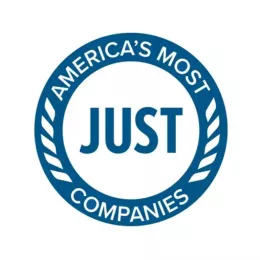 Logo of "America's Most JUST Companies" featuring bold white text centered within a blue circular seal, bordered by laurel wreath designs.