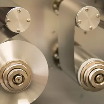 Close-up of precision-engineered metal parts with circular patterns and screws, likely components of mechanical or electronic equipment.