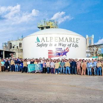group of employees in front of safety sign