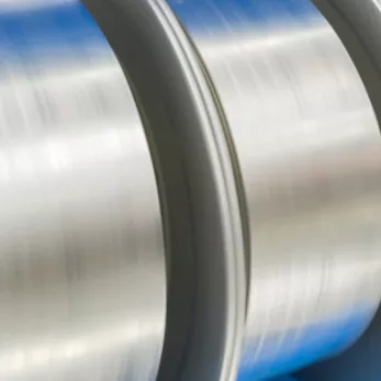 Close-up image of shiny, metallic industrial rollers, reflecting light.