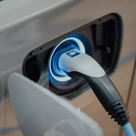 Close-up image of an electric vehicle charger plugged into a car.