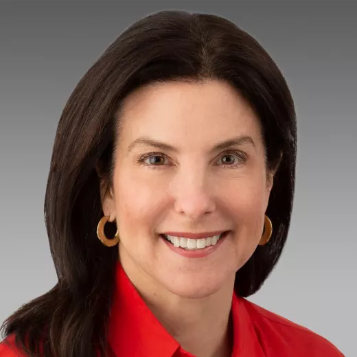 Headshot of Kristin Coleman, Executive Vice President, General Counsel and Corporate Secretary who is smiling with long dark hair, wearing a red blouse and gold hoop earrings.