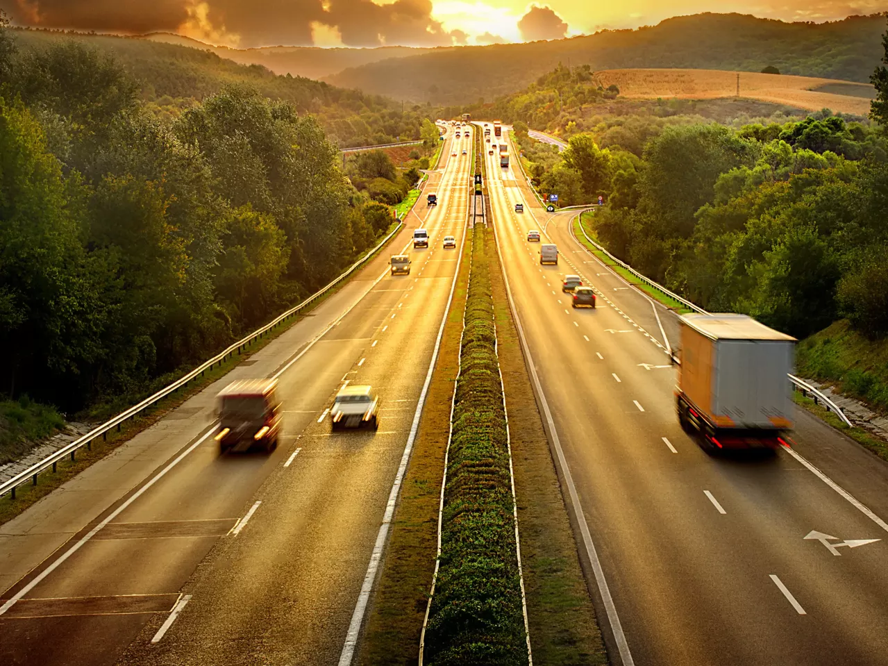 An aerial view of a highway with moving traffic.